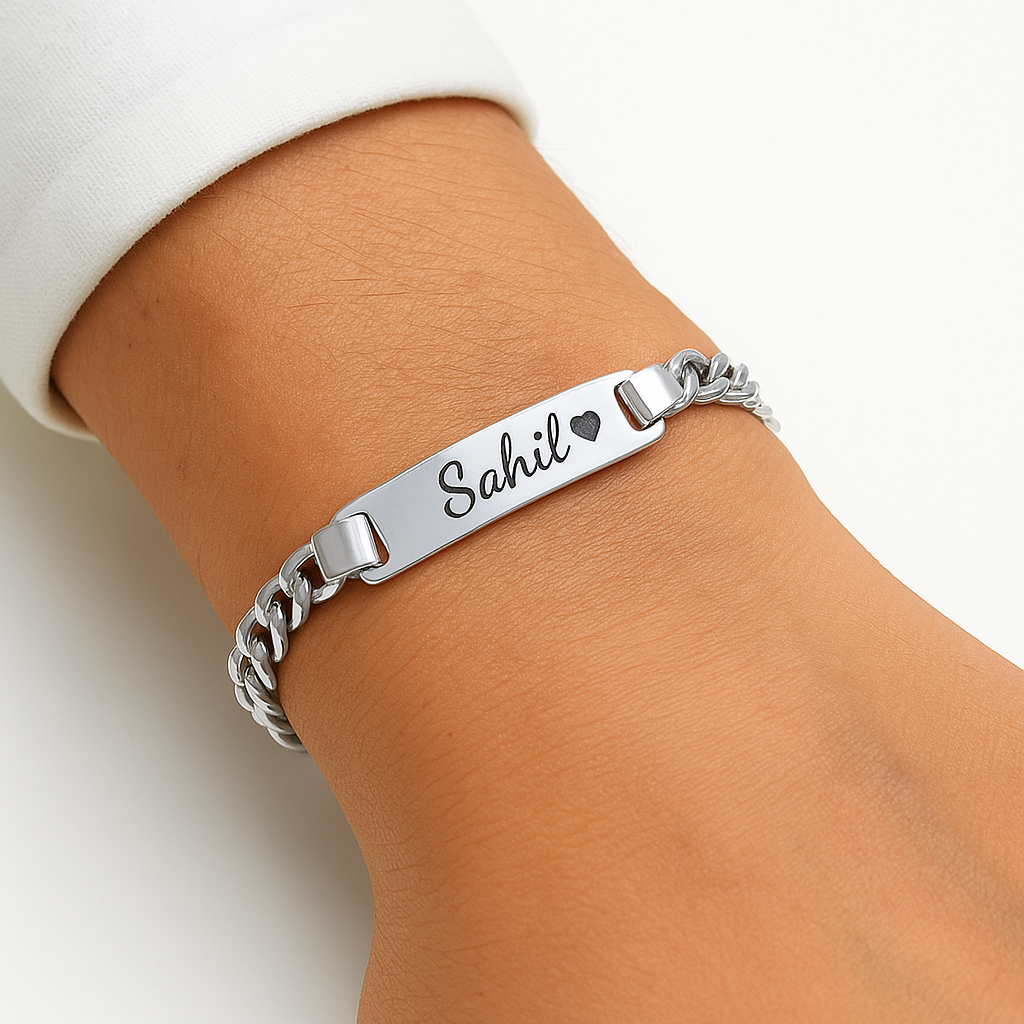 Silver bracelet with engraved name on wrist against a neutral background